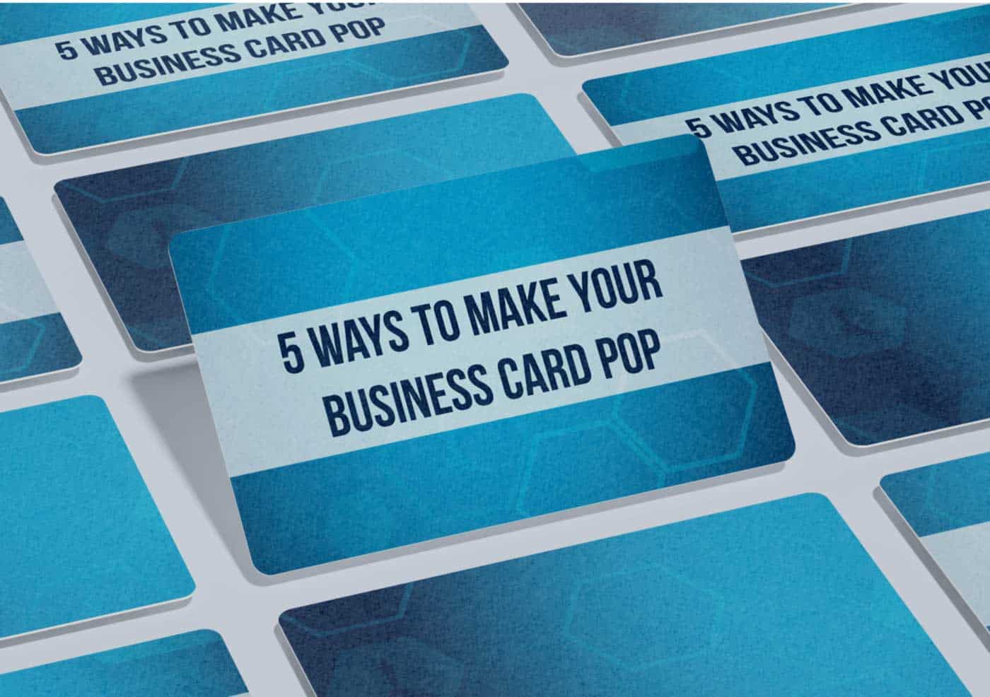 overhead shot of a table of business cards and caption "5 ways to make your business card pop"