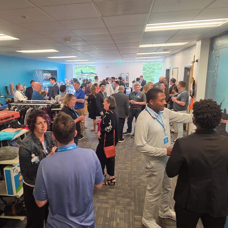 Networking event at Strategic Factory, with people gathered in hallway.