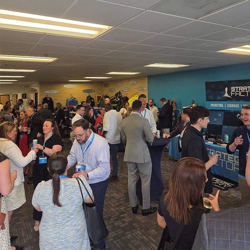 Networking event at Strategic Factory, with people gathered in hallway.