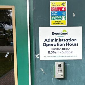 everstand branded wayfinding signage with listing of facility hours