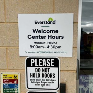 everstand branded wayfinding signage with listing of facility hours