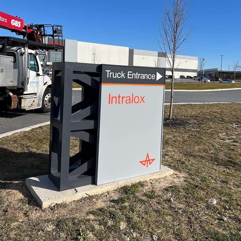 short wayfinding pylon sign that marks the truck entrance for a distribution facility